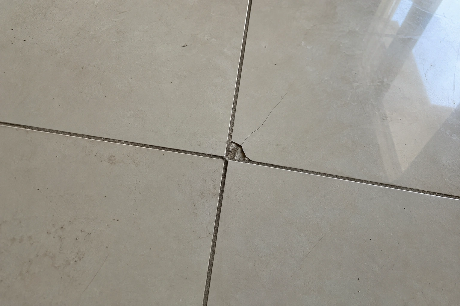 Detalhe de piso com peça quebrada visto em primeira pessoa durante a vistoria